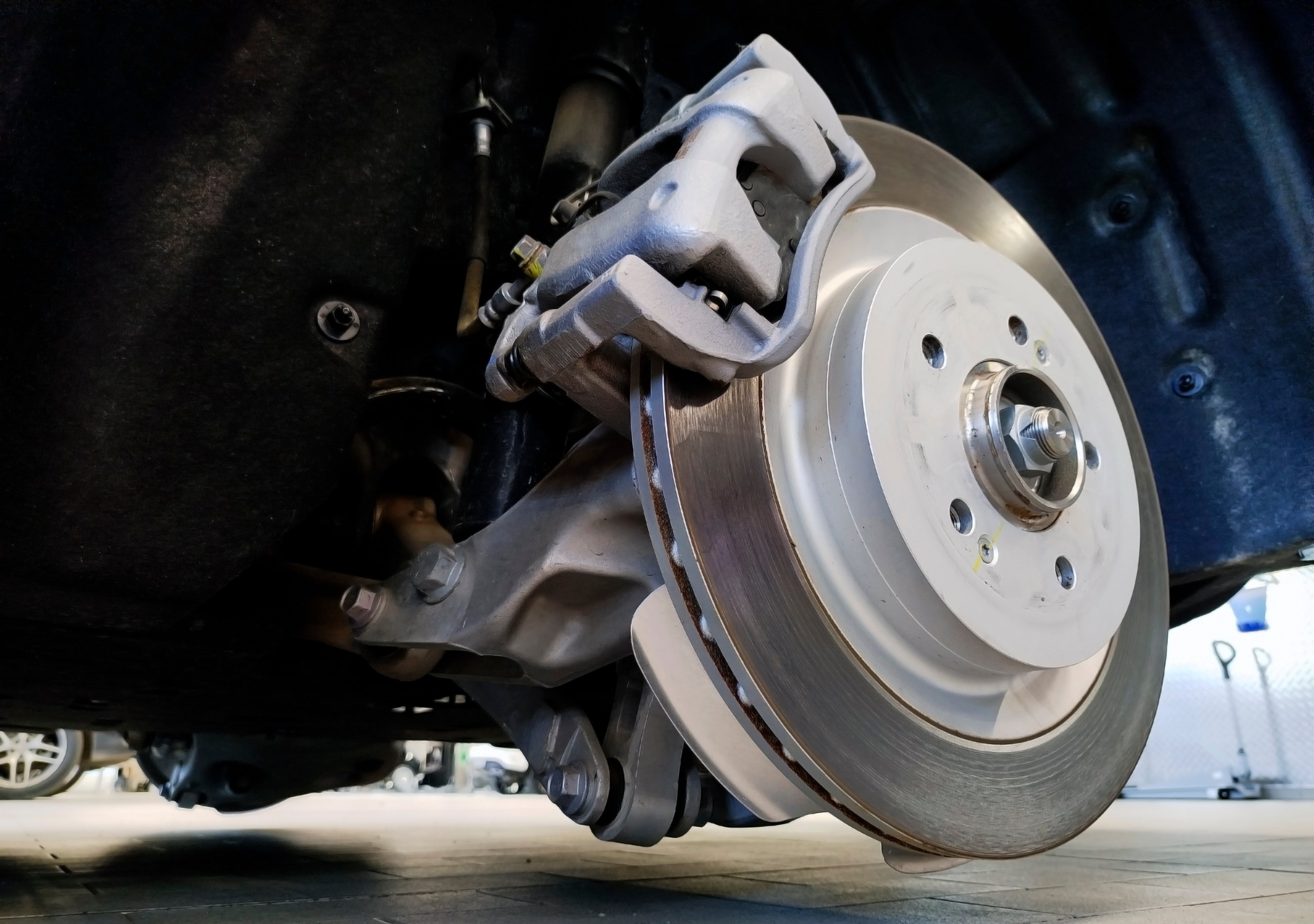 Close-up of a vehicle’s brake rotor and caliper during inspection.